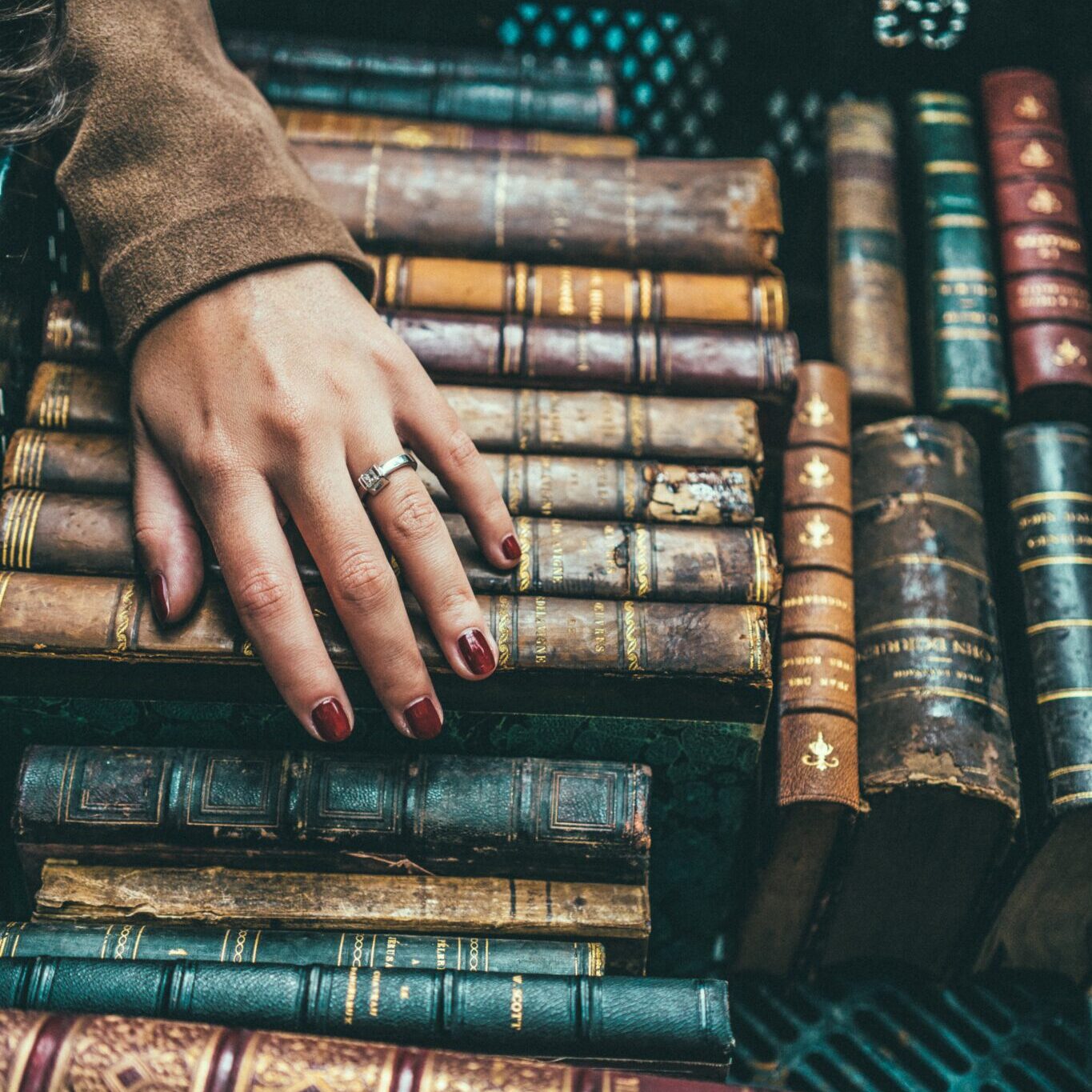 a female hand on old books